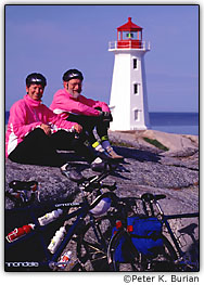 Casal de ciclistas perto de um farol