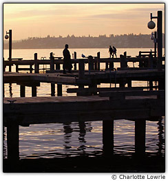 Pessoas caminhando em p�ers ao p�r do sol