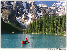 Canoa em um lago rodeado por montanhas