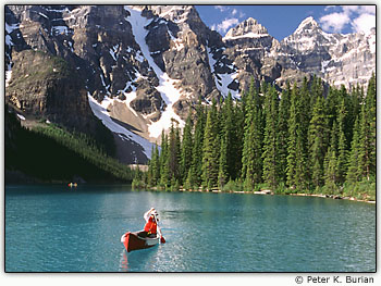 Canoa em um lago rodeado por montanhas